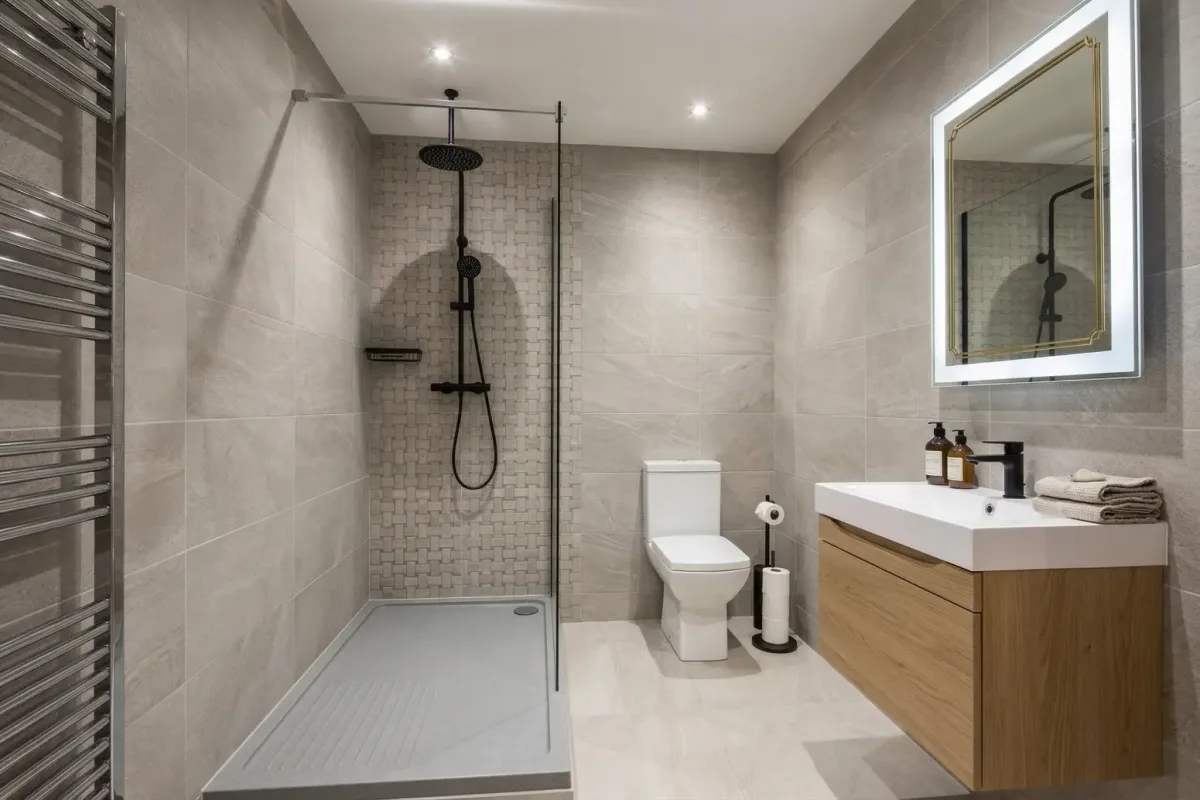 Compact shower room with oak vanity storage and black fittings